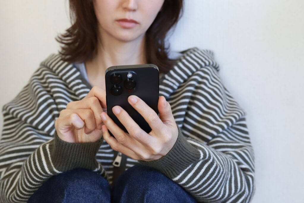 めんどくさそうにLINEする女性