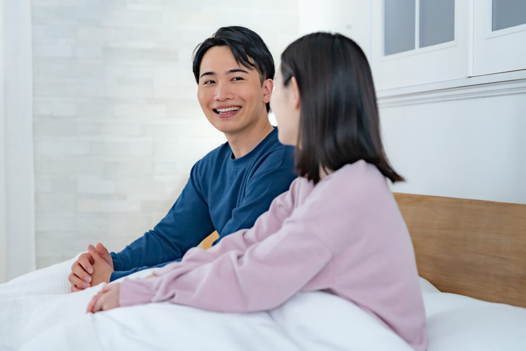 ベッドで会話する同棲カップル