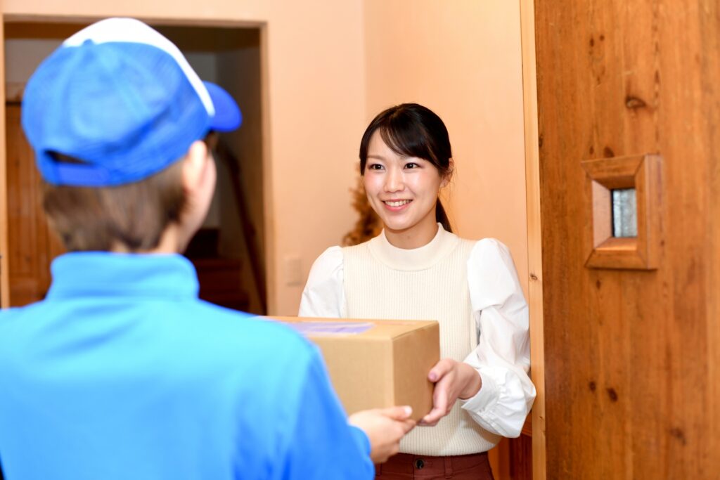業者に荷物をわたす女性